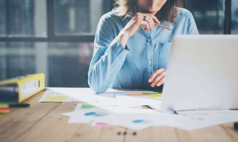 Woman working at her computer considering taking a new job