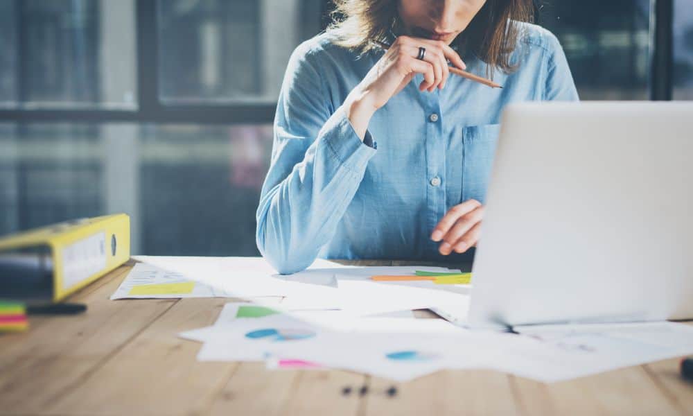 Woman working at her computer considering taking a new job