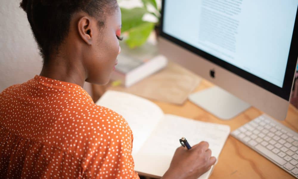 Woman working at desk taking notes