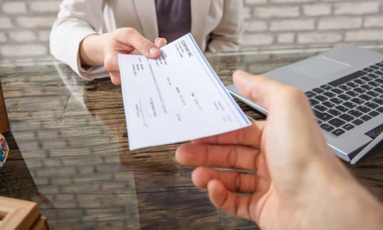 Employer handing paycheck to employee