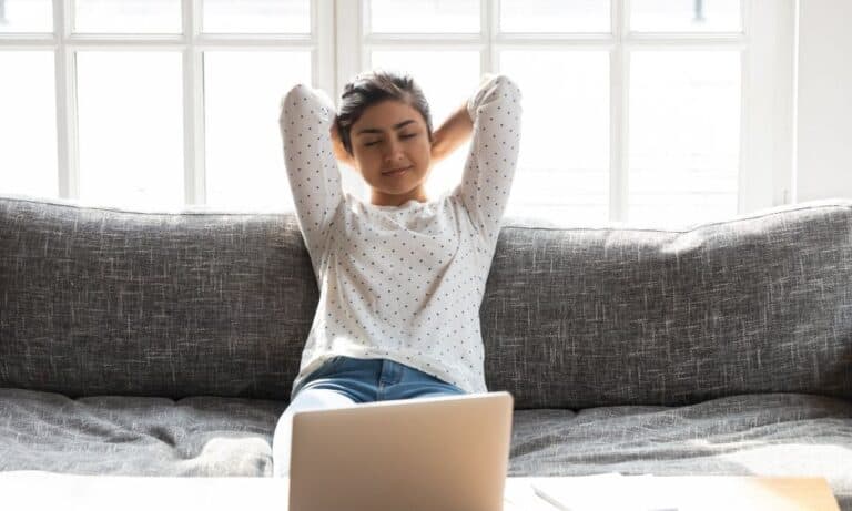 Woman resting on couch after working on computer