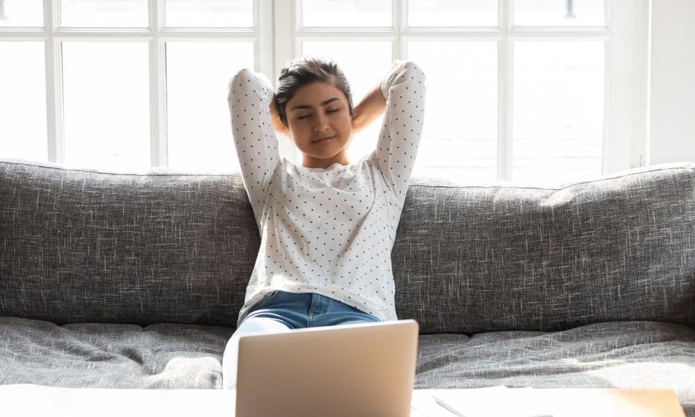 Woman resting on couch after working on computer