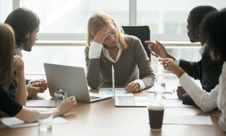 Employees confront team member in conference room
