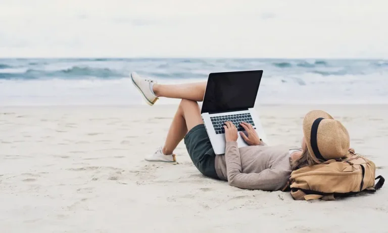 Freelancer working from beach on computer