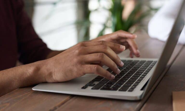 Photo of an employee typing on a MacBook.