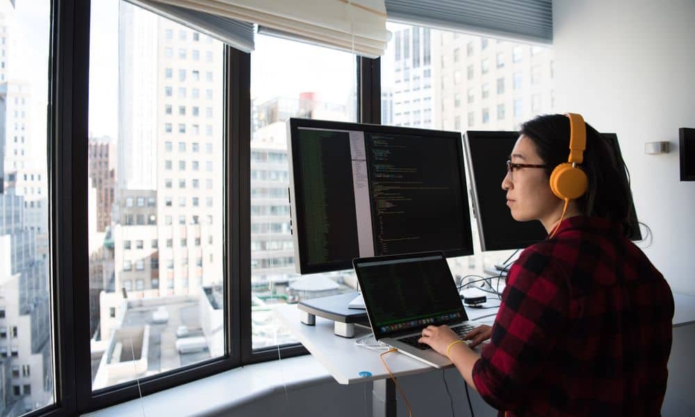 Photo of an employee working on multiple screens.