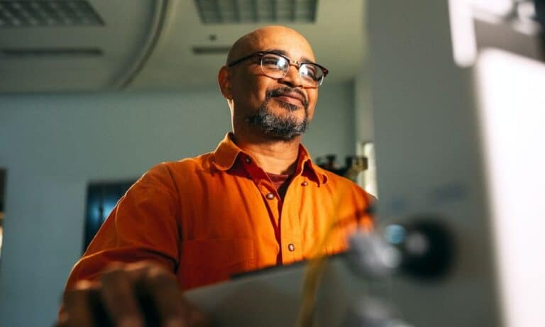 Employee smiling at his computer.