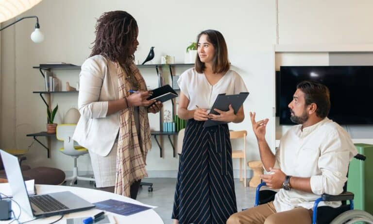 Photo of employees discussing in an office together.