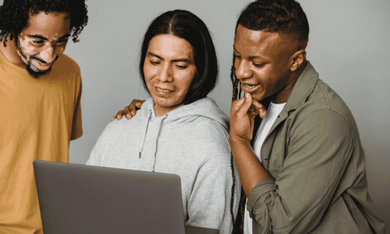 Photo of employees looking at a laptop together.