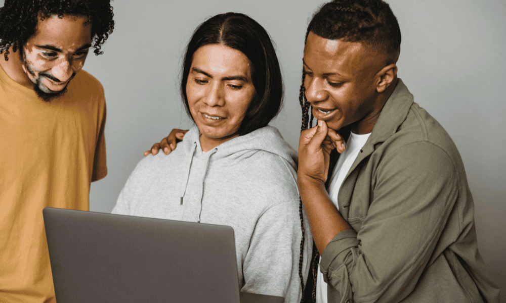 Photo of employees looking at a laptop together.