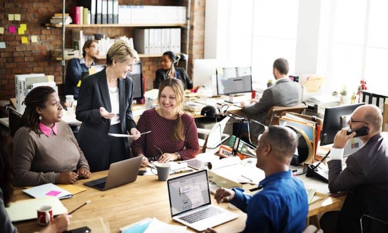 Employees working in the office and chatting with manager