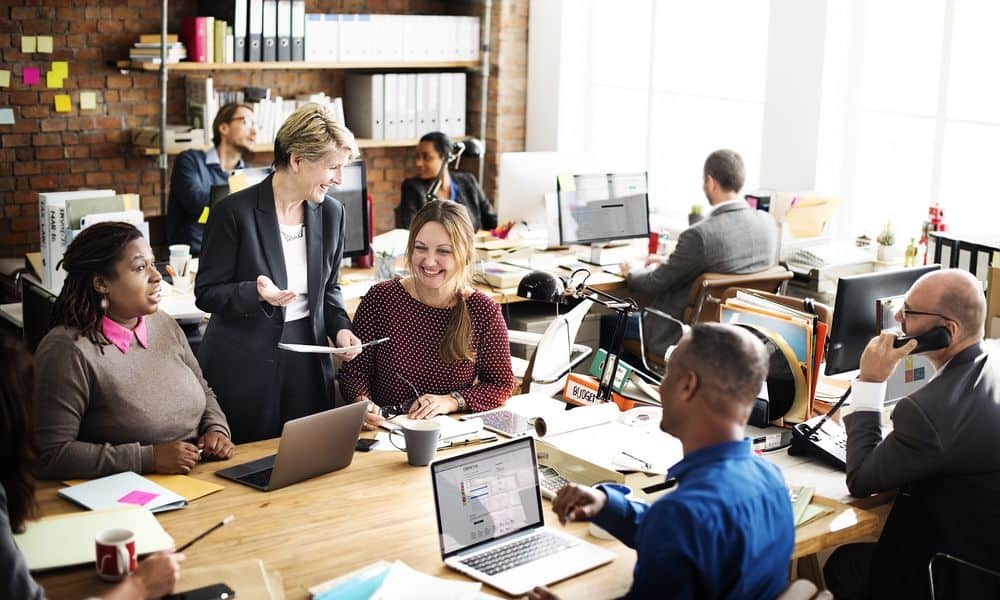 Employees working in the office and chatting with manager