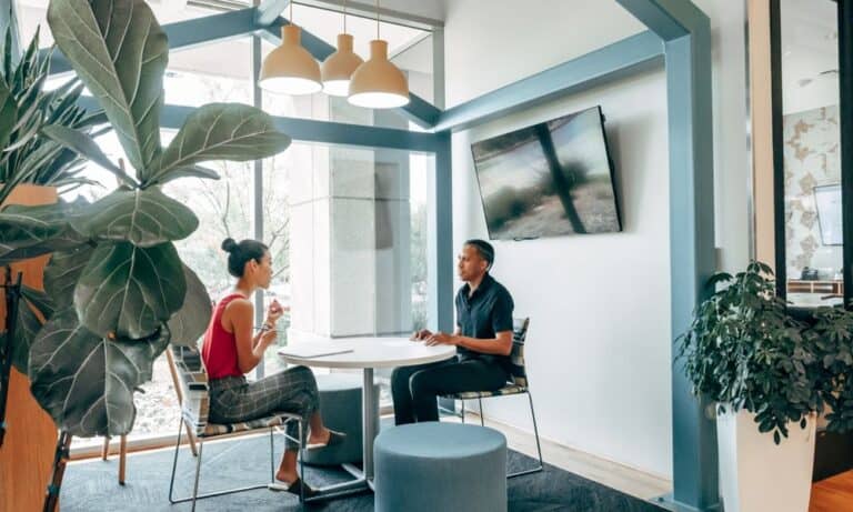 Employees sitting at a table in an office space.