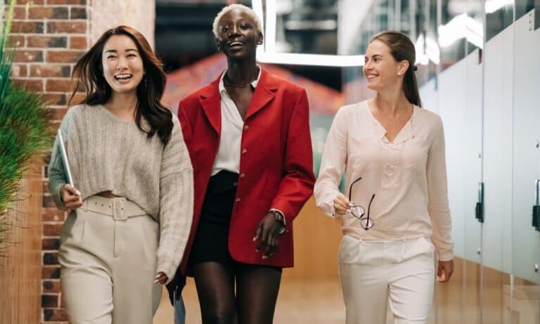 Employees walking in an office and smiling.