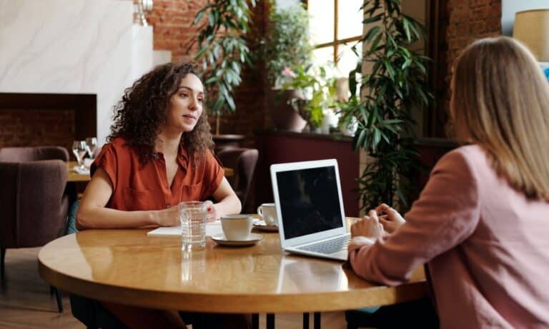 Photo of an employer talking to a web designer.