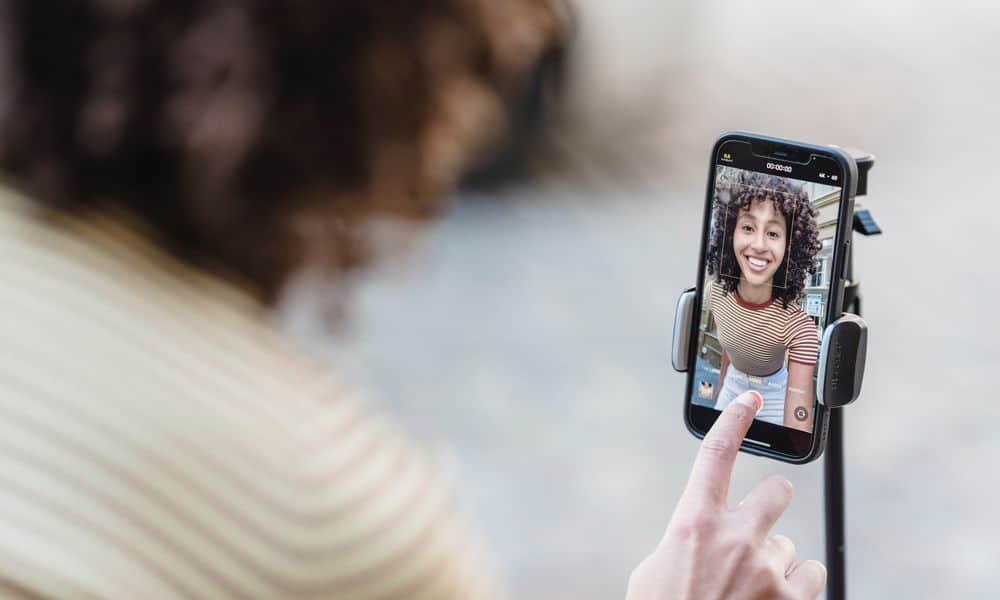 Photo of an influencer recording themselves with a tripod.