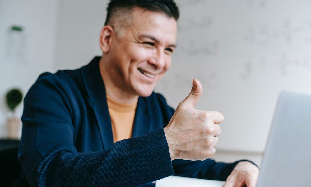 Photo of a remote worker giving a thumbs up.