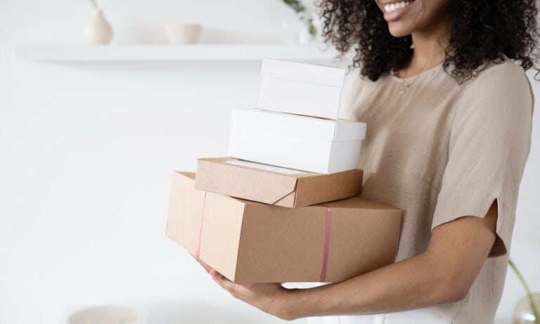 Photo of a retail sales associate holding gift boxes.