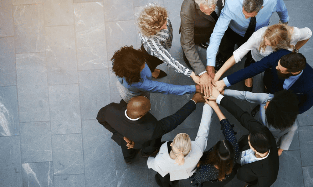 Photo of a team joining hands in a circle.