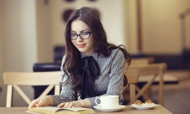 Woman Reading at a Table drinking coffee