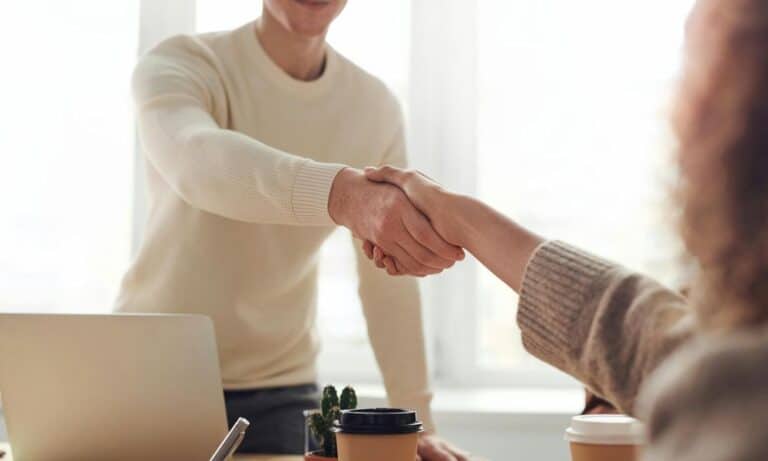 Photo of employer shaking hand of employee