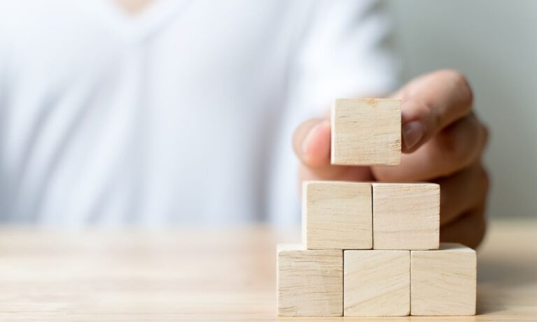 Man placing building blocks
