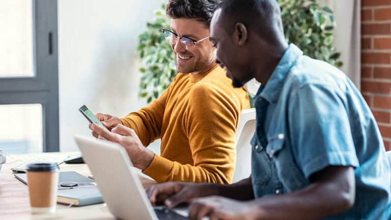 Photo of marketing team member showing mobile experience to a colleague