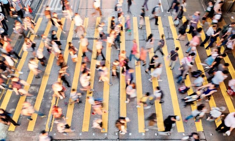 People crossing street in crosswalk in city