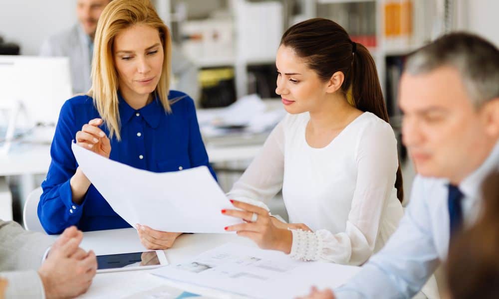 Coworkers discussing project in conference room