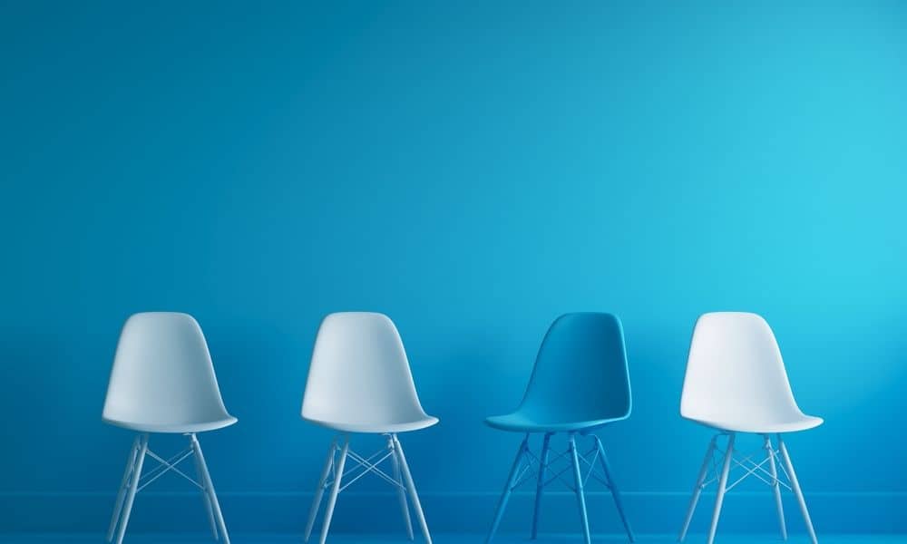 Photo of four chairs with a blue backdrop.