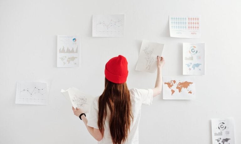 Photo of a freelancer hanging up papers on a wall.