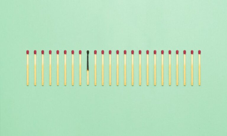 Photo of matches lined up on a green background.