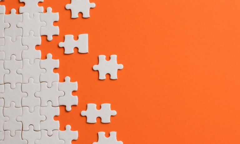 Photo of puzzle pieces on an orange background.