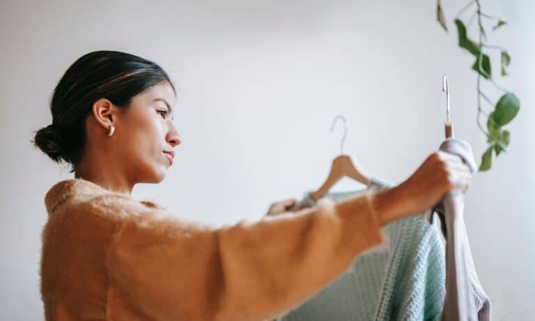 Photo of a retail employee holding clothing.