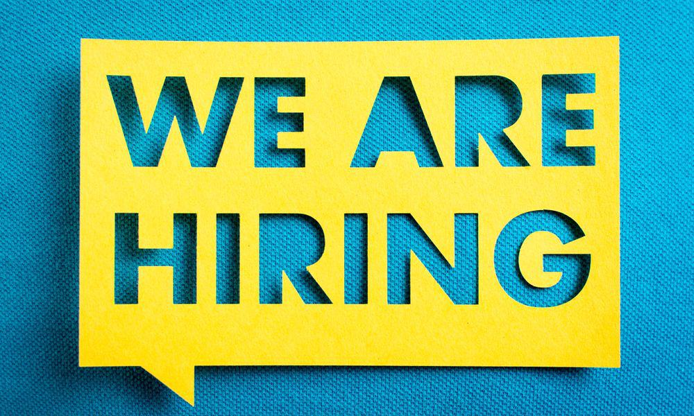 Photo of "We Are Hiring" in a cutout piece of paper.