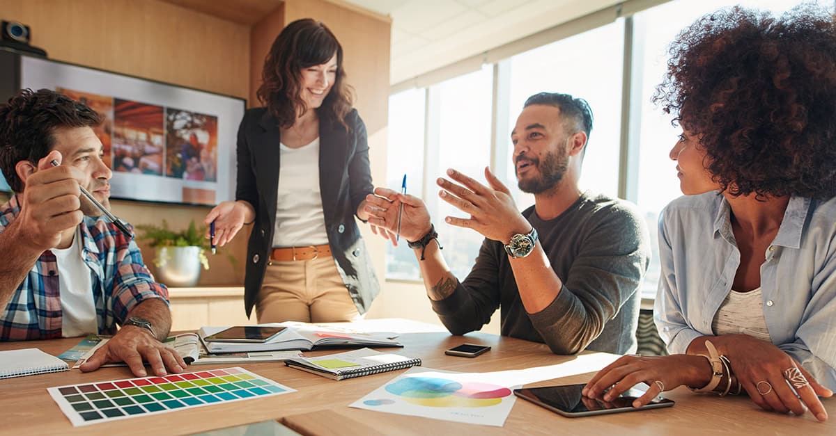 Diverse group of creatives, collaborating at a table in office