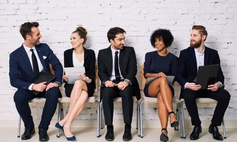 Row of candidates in waiting room wait to be interviewed