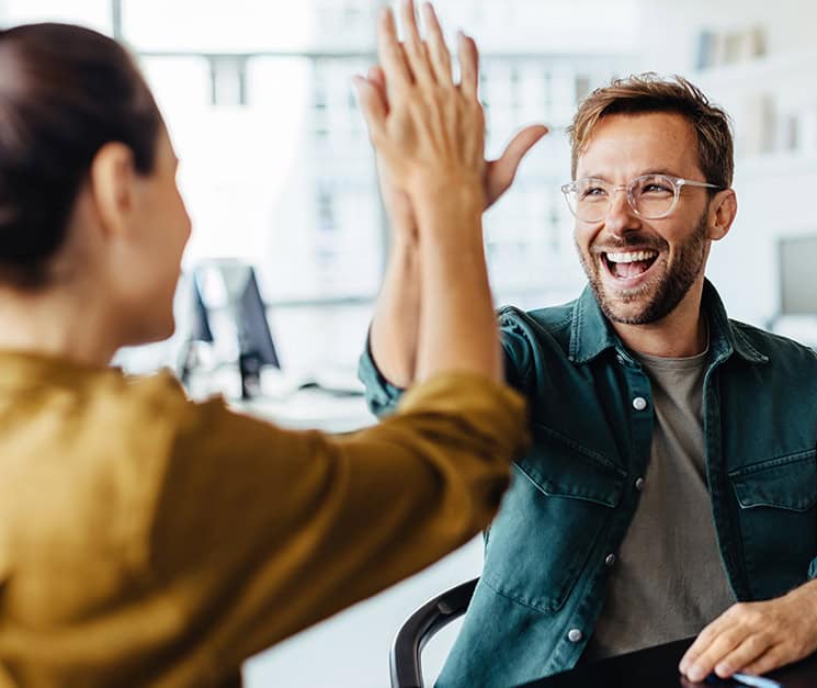Two colleagues celebrating a win with a high-five