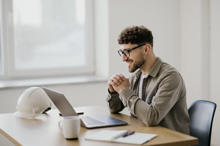 Photo of a man on a video conference with a construction hat.