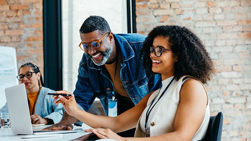 Two colleagues reviewing content together